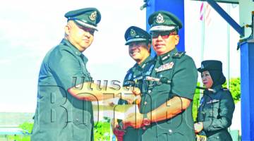 ZAINI (kanan) menyampaikan sijil kepada pegawai polis.