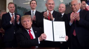 IKTIRAF: Trump memegang dokumen pengiktirafan kedau-latan Israel ke atas Dataran Tinggi Golan di hadapan Perdana Menteri Israel Benjamin Netanyahu dan yang lain di Rumah Putih di Washington DC pada Isnin. — Gambar AFP