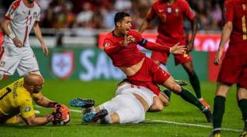 TERJAHAN KERAS: Ronaldo diterjah oleh Nikola Milenkovic pada aksi kelayakan Euro 2019 Kumpulan B di antara Portugal dan Serbia di Stadium the Luz, 25 Mac lepas. — Gambar AFP