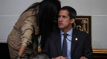 IMUNITI DILUCUT: Seorang kakitangan membisikkan maklumat kepada Guaido (kanan) ketika sesi Perhimpunan Kebangsaan di Caracas, Venezuela pada Selasa. — Gambar Reuters