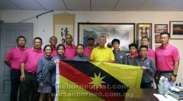 SELAMAT BERJUANG: Ting bersama yang lain merakam kenangan bersama pemain muda golf selepas majlis ringkas penyerahan bendera Sarawak di Miri, petang kelmarin.
