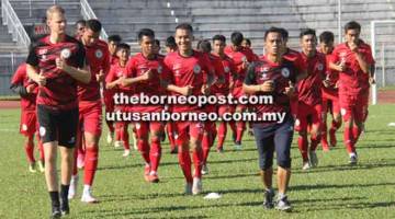 SEDIA GEMPUR: Penolong jurulatih Sarawak, Ronald Hikspoors dan Edward Jamid Unting mengepalai barisan pemain memanaskan badan sebelum memulakan sesi latihan di Kuching petang semalam.