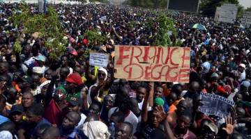 TIDAK PUAS HATI: Orang ramai menyertai rapat umum untuk membantah kegagalan kerajaan dan anggota pengaman antarabangsa untuk membendung keganasan etnik dan pelampau jihad, di Bamako kelmarin. Poster itu menyebut ‘Perancis keluar’. — Gambar Reuters