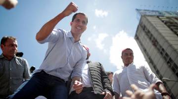 TEGAR: Guaido menyapa para penunjuk perasaan yang turut menghadiri rali mengecam Maduro di Caracas, kelmarin. — Gambar Reuters