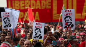 BEBASKAN LULA!: Penyokong Lula berhimpun untuk menuntut pembebasannya setahun selepas bekas presiden itu dipenjara                           di Sao Paulo, Brazil pada Ahad. — Gambar Reuters