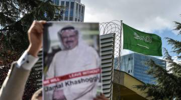 TUNTUT KEADILAN: Dalam gambar fail yang diambil pada 5 Oktober 2018, penunjuk perasaan membawa gambar Khashoggi sewaktu demonstrasi di depan konsulat Arab Saudi di Istanbul, Turki. — Gambar AFP