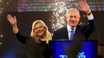 YAKIN MENANG: Netanyahu dan Sara melambai ketika Netanyahu berucap selepas tinjauan awal dalam pilihan raya umum Israel di Ibu Pejabat Parti Likud di Tel Aviv pada Rabu. — Gambar Reuters