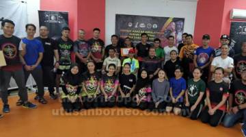 PERKEMBANG MUAYTHAI: (Duduk dari kanan) Norizan dan Ahmad Rodzli bergambar kenangan bersama para peserta, jurulatih dan tetamu lain selepas kursus berakhir. 