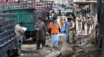 AKIBAT SERANGAN BOM: Pegawai keselamatan memeriksa tapak letupan bom di pasar buah-buahan di Quetta pada Jumaat. — Gambar AFP