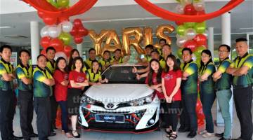 TEMUI KAMI: Ang (kanan) bersama para kakitangannya mempamerkan model terbaharu Toyota All-New Yaris di Sibu, semalam.