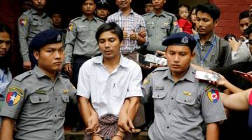 DALAM TAHANAN: Kyaw Soe Oo dan Wa Lone diiringi polis ketika meninggalkan mahkamah di Yangon, Myanmar, dalam gambar fail bertarikh 20 Ogos 2018. — Gambar Reuters