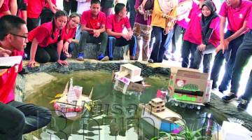 PARA peserta menguji prototaip kapal laut masa hadapan di dalam kolam sekolah.