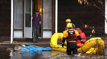 MEMANTAU: Pegawai memeriksa keadaan seorang penduduk rumah yang banjir di kawasan Constance Bay di Ottawa, Ontario di Kanada, kelmarin. — Gambar Reuters 