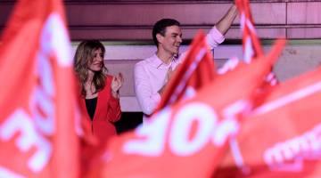 MENANG: Sanchez melambai di sebelah isterinya Begona Gomez semasa rali malam pilihan raya                di Madrid selepas Sepanyol mengadakan pilihan raya umum kelmarin. — Gambar AFP