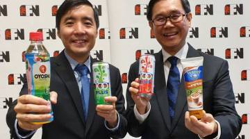 PRODUK BAHARU: Lim (kanan) dan Ketua Pegawai Kewangan F&N Holdings Bhd Lai Kah Shen menunjukkan beberapa produk F&N selepas taklimat dengan media mengenai dalam keputusan separuh pertama di Kuala Lumpur, semalam. — Gambar Bernama