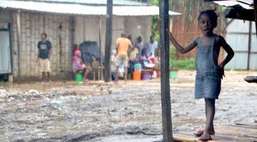 DILANDA SIKLON: Seorang budak perempuan berdiri di luar rumahnya di Paquite, daerah Pemba kelmarin ketika Siklon Kenneth melanda bahagian utara Mozambique. — Gambar AFP