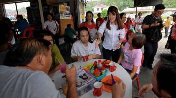 BERKEMPEN: Vivian (tengah) beramah mesra dengan sebahagian pelanggan sebuah kedai makan ketika mengadakan kempen bagi Pilihan Raya Kecil Parlimen P186 Sandakan di Indah Jaya semalam. — Gambar Bernama 