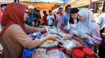 Dr Wan Azizah (kanan) diiringi Wong melihat kuih tradisional yang dijual di Pasar Tamu Mingguan ketika mengadakan lawatan mesra hari ini. - Gambar Bernama 
