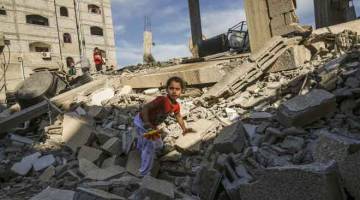 MUSNAH: Kanak-kanak Palestin memanjat runtuhan bangunan yang musnah selepas serangan udara oleh tentera Israel ke atas Rafah di Semenanjung Gaza kelmarin. — Gambar AFP
