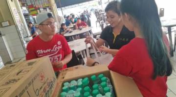 PROMOSI: Kakitangan Wen Ken Group (Cap Kaki Tiga) melancarkan mempromosikan set pembelian air penyejuk badan Cooltopia pada pelancaran Jerayawara Aktivasi Air Cap Kaki Tiga di tiga medan selera di bandar raya Kuching.