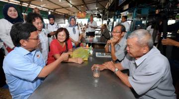 BERKEMPEN: Mohd Shafie (kiri) berbual dengan sebahagian pelanggan sebuah kedai makan ketika mengadakan tinjauan mesra ke Pasar Kim Fung sempena kempen PRK Parlimen Sandakan semalam. — Gambar Bernama 