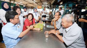 SHAFIE kiri) berbual dengan sebahagian pelanggan sebuah kedai makan ketika mengadakan tinjauan mesra ke Pasar Kim Fung sempena kempen Pilihan Raya Kecil (PRK) Parlimen Sandakan.