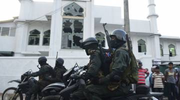 BERJAGA-JAGA: Tentera Sri Lanka yang lengkap bersenjata menunggang motosikal di hadapan                  Masjid Jumha selepas rusuhan anti-Islam melanda wilayah Minuwangoda semalam. — Gambar AFP