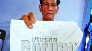 SEORANG petani, Ijang Utan, 76, menunjukkan pelan tanah yang menjadi pertikaian di Kampung Kayul, Kuala Penyu.