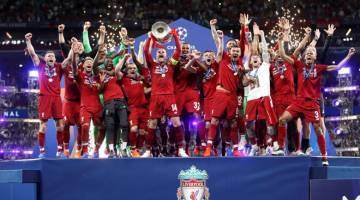 PENUH BERMAKNA: Henderson menjulang trofi kejuaraan ketika meraikan kejayaan menjuarai Liga Juara-Juara selepas menewakan Spurs di Stadium Wanda Metropolitano, Madrid kelmarin. — Gambar AFP 