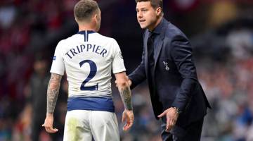 TETAP BANGGA: Pochettino memberi arahan kepada Trippier ketika perlawanan di Stadium Wanda Metropolitano, Madrid kelmarin. — Gambar AFP 