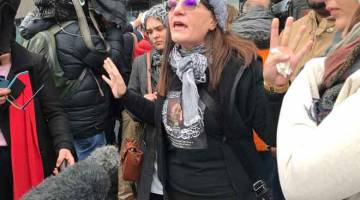MARAH: Janna Ezat, memakai kemeja-T yang memaparkan gambar anak lelakinya yang ditembak mati di masjid Al Noor pada 15 Mac lalu, menunjukkan reaksi marah di luar Mahkamah Tinggi Christchurch di New Zealand kelmarin selepas Tarrant mengaku tidak bersalah ke atas semua tuduhan berkaitan dengan serangan ganas itu. — Gambar Reuters