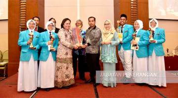 MOHAMMAD (lima dari kanan) menyampaikan Piala Pusingan Ketua Menteri kepada guru pengiring SMK Tawau.