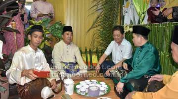 TAMPIL KEUNIKAN: Mohamaddin diiringi Abdul Karim meluangkan masa menjamu selera di salah satu gerai makanan tradisi.