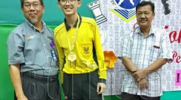 MOHD Jamatin (kiri) menyampaikan medal kepada juara Lelaki 18, Wong Wei Hao dari SMK Labuan. Turut kelihatan Subari Dwar (kanan).