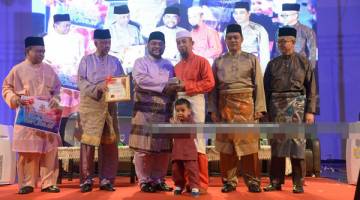 Dr. Mujahid (tiga kiri) menyampaikan Tokoh Asnaf 2019 kepada Norazlan Mahmood sambil diperhatikan Rozman (kanan) dan Haji Amir (2 kanan) sempena Majlis Tautan Kasih Aidilfitri 2019, di Dewan Arena Bukit Kuda, baru-baru ini.