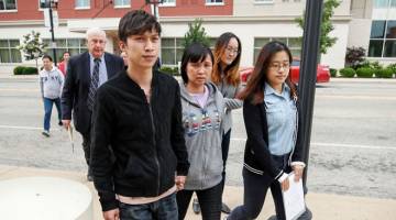 PERBICARAAN: Gambar fail 12 Jun lalu menunjukkan Lifeng Ye (tengah) dan Zhengyang Zhang (kiri), masing-masing ibu dan abang Zhang tiba di mahkamah ketika perbicaraan Christensen bermula. — Gambar AFP