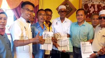 BEKAS ketua-ketua cawangan Umno menyerahkan borang keahlian Warisan kepada Ahmaddun (dua kanan). Turut kelihatan Wong (dua kiri). 