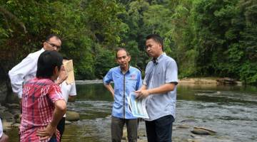MANFAAT: Peter (kanan) berbincang bersama penduduk sambil melihat peta lokasi Sungai Papar ketika melawat lokasi pembinaan empangan Papar semalam. — Gambar Bernama 