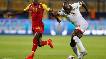 LAKAR KEJUTAN: Pote (kanan) mengawal bola ketika cuba melepasi kekangan pemain Ghana  pada aksi di Stadium Ismailia, Mesir kelmarin. — Gambar AFP