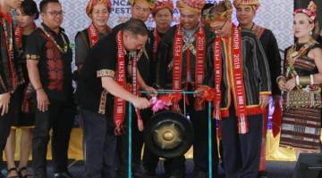 Abd Latif memukul gong simbolik merasmikan Pesta Magahau Zon Kota Kinabalu 2019.