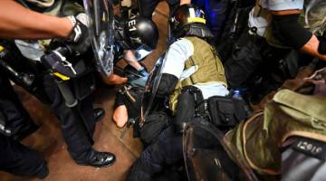 KECOH: Polis menangkap penunjuk perasaan semasa pertelingkahan di daerah Mong Kok                        di Kowloon selepas satu perarakan ke terminal kereta api di Kowloon Barat untuk membantah                    rang undang-undang ekstradisi di Hong Kong kelmarin. — Gambar AFP