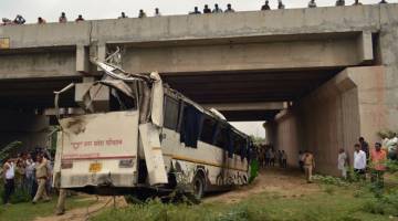 TERBABAS: Orang ramai dan anggota polis berkumpul sekitar rangka bas selepas ia terbabas dari lebuh raya Yamuna dari Delhi ke Agra dan mengorbankan 29 nyawa, berhampiran Agra, India,                              semalam. — Gambar AFP