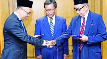 SHAFIE ( tengah) menyaksikan penyerahan Zakat Perniagaan PNB daripada Rahman (kiri) kepada Hasbullah.