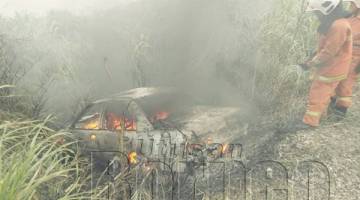 .ANGGOTA bomba menjalankan pemadaman api marak memusnahkan kereta sedan yang dinaiki mangsa.