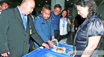 SIM (tiga dari kiri) dan Mary (empat dari kiri) menyaksikan proses penguatkuasaan bagi penerbangan dari Guangzhou.