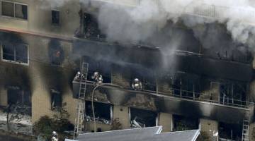TERBAKAR: Gambar serahan agensi berita Kyodo menunjukkan anggota bomba menangani kebakaran di bangunan milik                        sebuah syarikat animasi di kota Kyoto, Jepun, semalam. — Gambar Reuters
