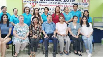 LAWRENCE (duduk, tengah) merakam gambar kenangan bersama pihak penganjur bazar amal 2019 yang dianjurkan oleh Persatuan Rumah dan Perkhidmatan Cheshire Sabah selepas sidang media berkenaan. 