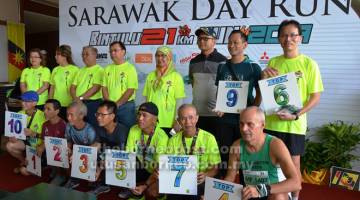 TAHNIAH: Sepuluh pelari meraih kedudukan 10 terbaik kategori 21km lelaki (46 tahun ke atas) bersama Dr Rundi, John Sikie, Loreta, Melia (kiri) serta Rodziah dan Dino. 