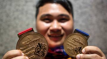 Bonnie menunjukkan pingat emas yang dimenanginya ketika tiba di KLIA hari ini. - Gambar Bernama 