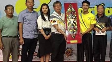 TAHNIAH: Hii (kanan) menerima hadiah daripada Presiden Persatuan Tarian Naga, Tarian Singa dan Wushu Negeri Sarawak (PTNSWS), Lee King Choon kelmarin.